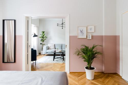 a bedroom with pink and white walls and a potted plant at Acropolis Heart 2BD Apartment in Plaka by UPSTREET in Athens