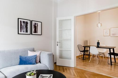 a living room with a couch and a table at Acropolis Heart 2BD Apartment in Plaka by UPSTREET in Athens