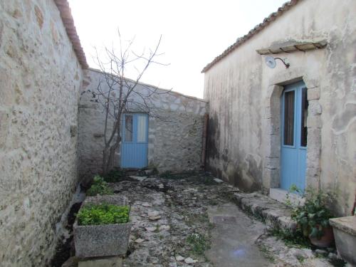 an alley between two buildings with blue doors at Casa Sarculla in Testa dellʼAcqua