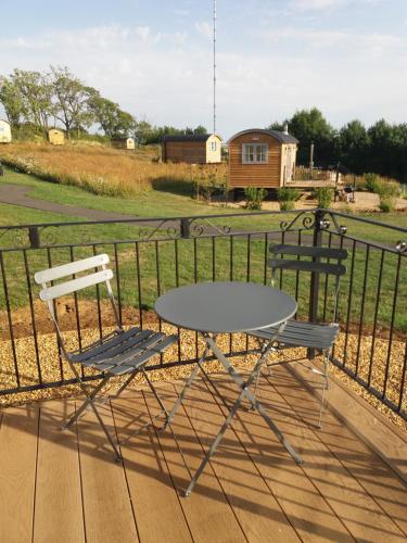 a table and two chairs sitting on a deck at Fair Farm Hideaway in Waltham on the Wolds