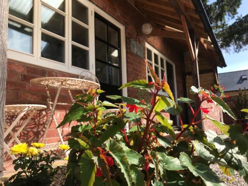 a porch of a brick house with a bunch of flowers at The Mill at Rose Villa Farm in Hereford