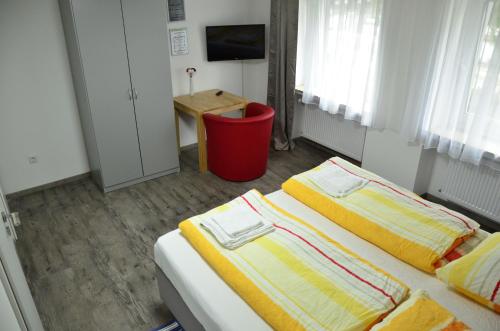 a bedroom with two beds and a desk in it at Hotel am Schloss in Paderborn