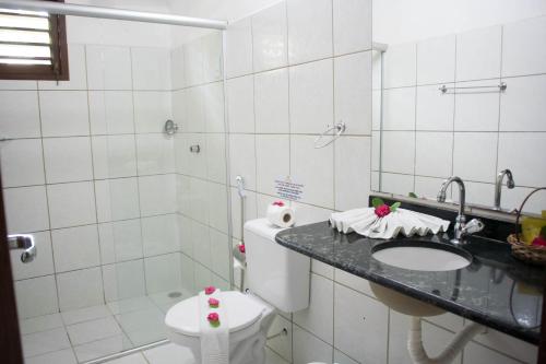 La salle de bains est pourvue de toilettes, d'un lavabo et d'une douche. dans l'établissement Pousada Sol e Luna, à Pipa