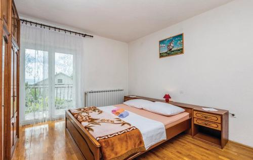 a bedroom with a bed and a table and a window at Apartment Blaza in Senj