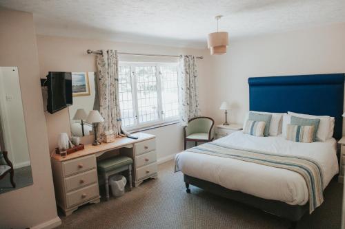 a bedroom with a bed and a desk and a window at The Lordleaze Hotel And Restaurant in Chard