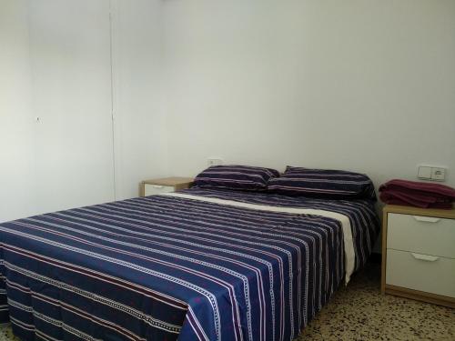 カンブリルスにあるCambrils Playaのベッドルーム1室(青と白のストライプの毛布付きのベッド1台付)