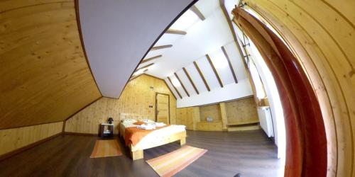 an attic room with a bed and a large window at Mansarda Maradu in Sinaia