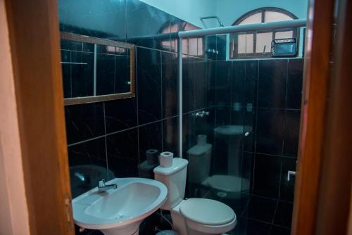 a bathroom with a toilet and a sink at Pousada do Caboclo in Ilhabela