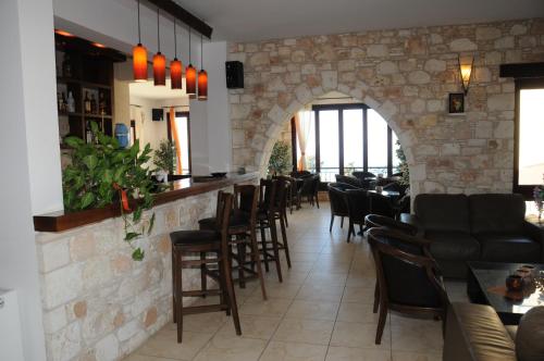 un restaurante con un bar con una pared de piedra en Palates Hotel en Droushia