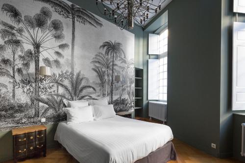 - une chambre avec un lit orné d'une fresque murale de palmiers dans l'établissement Apartment Le 1727, à Saint-Malo