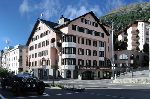 a black car driving past a large building at Hotel Rosatsch in Pontresina