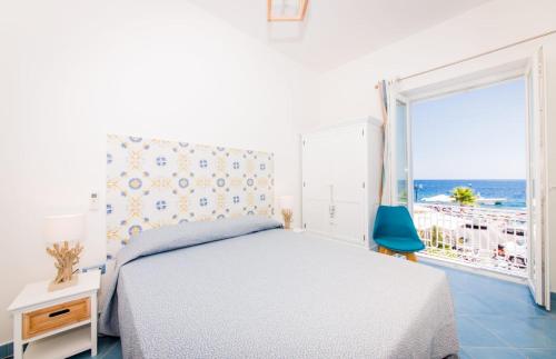 a bedroom with a bed and a view of the ocean at Zagma Un Passo Dal Mare in Canneto