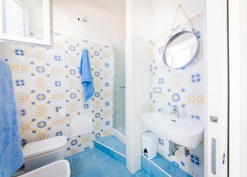 a blue and white bathroom with a sink and a mirror at Zagma Un Passo Dal Mare in Canneto