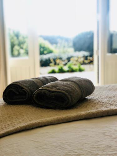 three rolled towels sitting on top of a bed at Cable Bay Luxury Villa in Oneroa