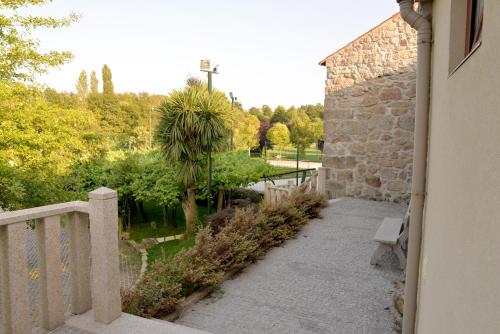 a stone building with a bench and a palm tree at Quinta dos Jasmins in Paços de Ferreira