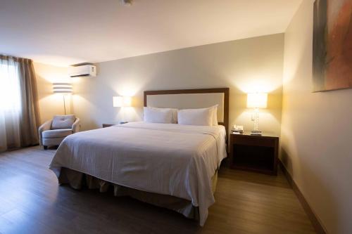 a hotel room with a bed and a chair at Antaris Valle in Monterrey