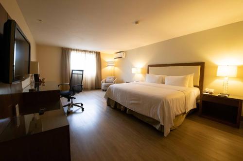 a hotel room with a bed and a flat screen tv at Antaris Valle in Monterrey