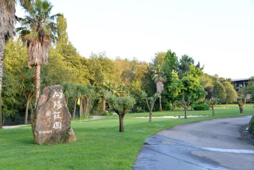a rock sitting in the grass next to a road at Quinta dos Jasmins in Paços de Ferreira