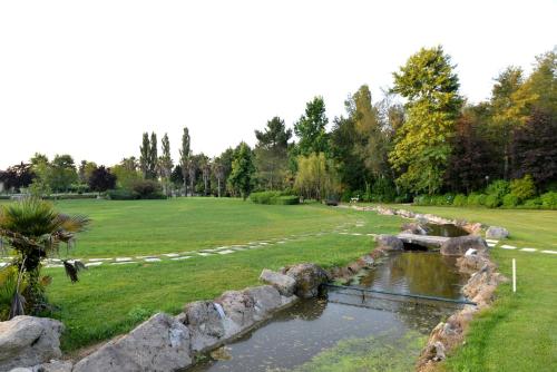 a river in a park with a rock wall at Quinta dos Jasmins in Paços de Ferreira