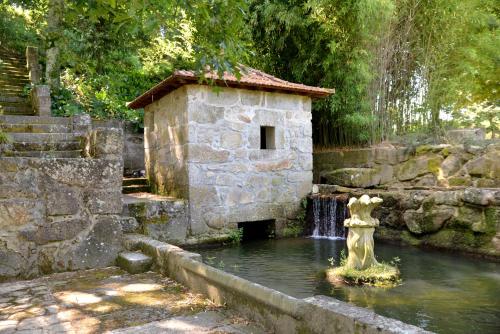 a fountain in a pond in a garden at Quinta dos Jasmins in Paços de Ferreira