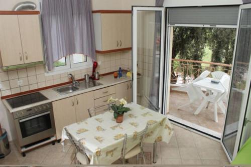 a kitchen with a table and a kitchen with a patio at Studios Stella in Skala Potamias