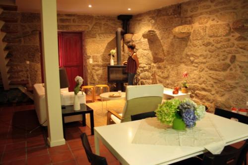 Eine Frau steht in einem Raum mit einer Steinwand in der Unterkunft Casa do Notário in Amares