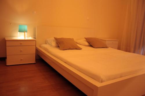 ein Schlafzimmer mit einem Bett mit einer Lampe auf einem Nachttisch in der Unterkunft Casa do Notário in Amares