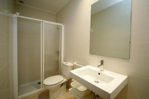 a bathroom with a toilet and a sink and a shower at Apartaments Les Roques in Platja d'Aro