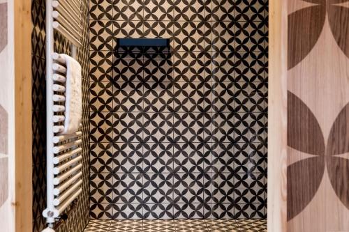 a bathroom with a black and white patterned wall at Peakini Farmhaus in Untertauern