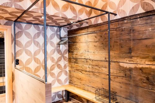 a shower in a bathroom with a wooden wall at Peakini Farmhaus in Untertauern