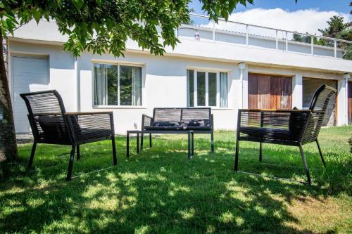 3 chaises et une table devant une maison dans l'établissement Dans mon jardin, à Ajaccio