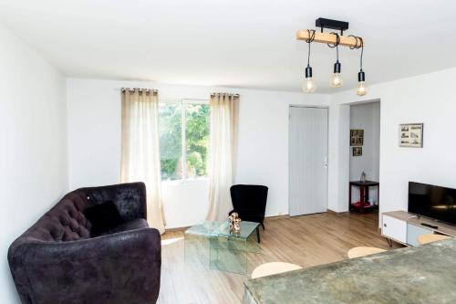 - un salon avec un canapé, deux chaises et une télévision dans l'établissement Dans mon jardin, à Ajaccio