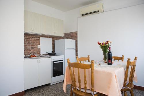 a kitchen with a table and a white refrigerator at Apartment Star in Split