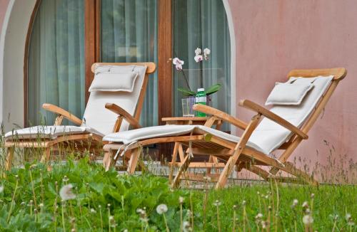 two lawn chairs sitting in front of a house at Hotel Rosatsch in Pontresina