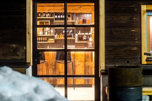 a glass door to a bar with a stool inside at Peakini Farmhaus in Untertauern