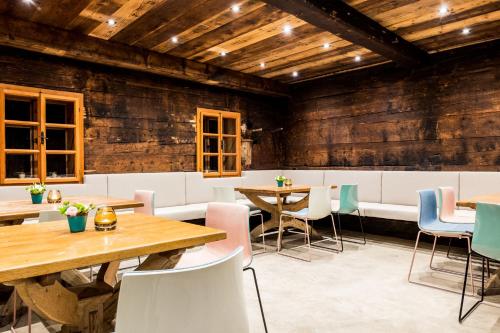 a restaurant with wooden walls and tables and chairs at Peakini Farmhaus in Untertauern