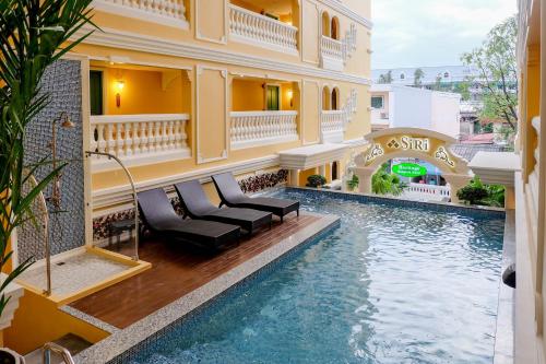 een zwembad in een gebouw met een hotel bij Siri Heritage Bangkok Hotel - SHA Extra Plus in Bangkok