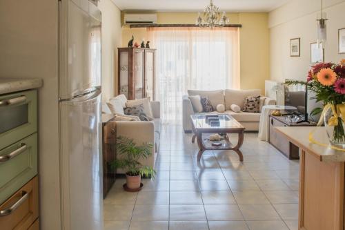 Artemis central apartment في Kórinthos: مطبخ وغرفة معيشة مع أريكة وطاولة