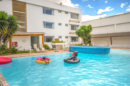 a swimming pool with two inflatables in the water at Hotel Ajavi in Ibarra