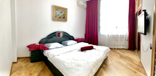 een kleine slaapkamer met een bed met rode gordijnen bij Calm center of Baku in Baku