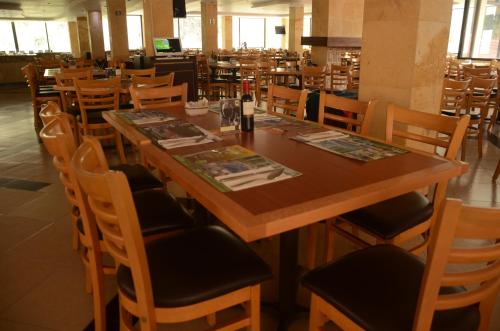 a dining room with a long wooden table and chairs at Hotel y Aguas Termales de Chignahuapan in Chignahuapan