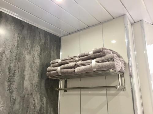 um monte de toalhas num cabide na casa de banho em DUNOON - TOWN CENTRE HOLIDAY HOME APARTMENT em Dunoon