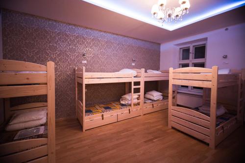 a room with three bunk beds and a chandelier at Greg&Tom Beer House Hostel in Kraków