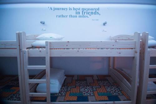 a room with two bunk beds with a quote at Greg&Tom Beer House Hostel in Kraków