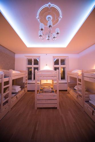 a room with three bunk beds and a chandelier at Greg&Tom Beer House Hostel in Kraków