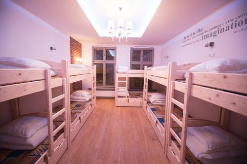 a room with four bunk beds in it with a chandelier at Greg&Tom Beer House Hostel in Kraków