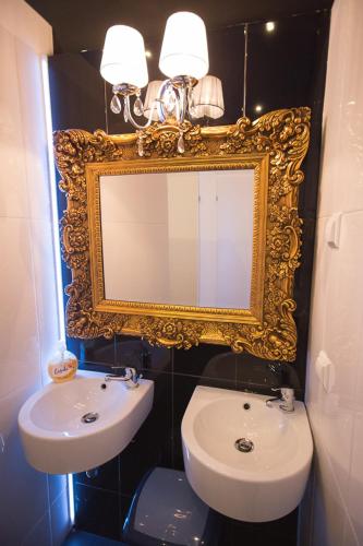 a bathroom with a sink and a mirror and a toilet at Greg&Tom Beer House Hostel in Kraków