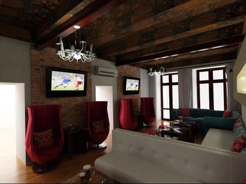 a living room with a couch and red chairs at Greg&Tom Beer House Hostel in Krakow