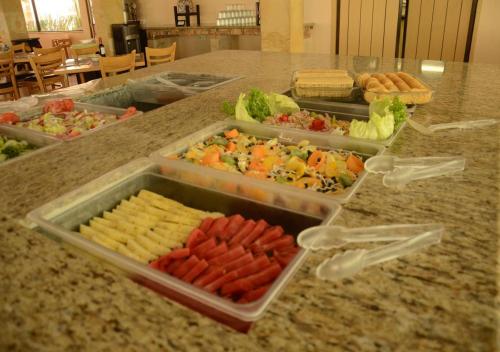a counter with trays of different types of food at Hotel y Aguas Termales de Chignahuapan in Chignahuapan