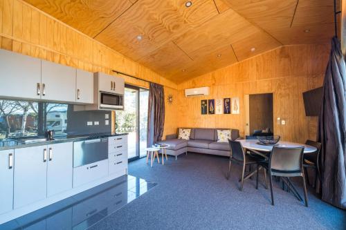 a kitchen and living room with a table and a couch at Queenstown Top 10 Holiday Park in Queenstown